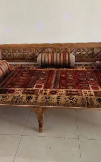 تخت سنتی چوبی همراه با فرش و بالشت