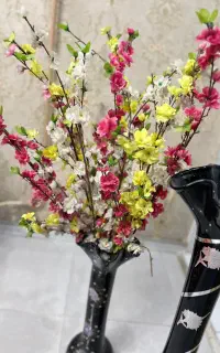گل و چند عدد گلدان شیشه ای و سفال
