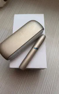 یک دستگاه iqos همراه با شارژر