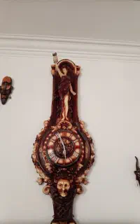 ساعت و مجسمه کنارش با شمعدانی