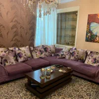 یک دست مبل ال ترک با کلی کوسن و میز جلو