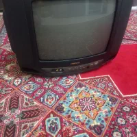 تلویزیون قدیمی رنگی همراه با کنترل مخصوص خونه باغ