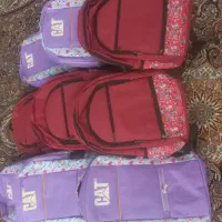 تعدادی کوله مدرسه و تعدادی کیف اداری.