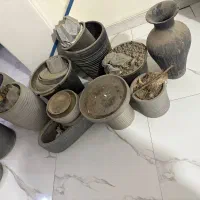 تعدادی گلدان کوچیک و بزرگ با زیرگلدان