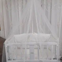 گهواره نوزاد چوبی سفید تمیز با تور