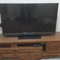 تلویزیون به همراه میز چوبی