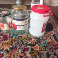 تعداد ی شیشه کوچک و دبه ماست سالم