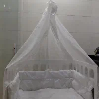 تخت نوزاد کنار مادر و وسایل کودک
