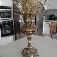 گلدان برنزی بزرگ و میز چوبی