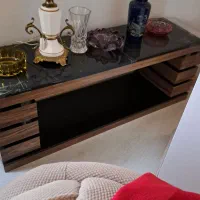میز زیرتلوزیون روش شیشه وسطش هم شیشه طبقه شیشه خور