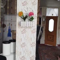 شلف تئزینی همراه با دو گلدان رنگی مصنوعی
