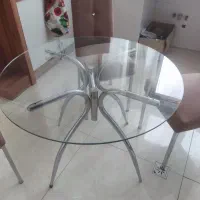 میز نهار خوری گرد شیشه ای بدون صندلی .