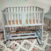 گهواره چوبی کنار مادر