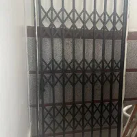 حفاظ در ورودی اکاردئونی و یک درب ورودی چوبی