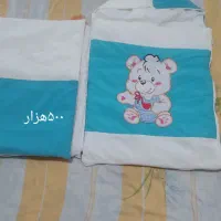 کیسه خواب کودک و تعدادی لباس بچه گانه