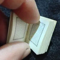 یک جلد قرآن کریم کوچک و بند انگشتی