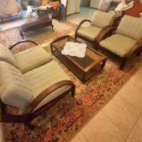مبل راحتی چوبی همراه با تشک ها و میز تمام چوب