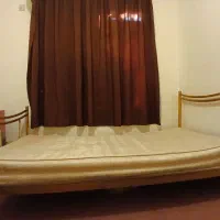 تخت خواب یک نفره و سندلی پشت میزی