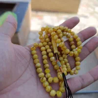 یک عدد تسبیح  کهربا  رگه  دار با دوتا چاقو