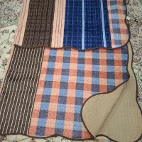 رو تختی دو نفره  ۳یا ۴ بار روی تخت انداخته شده