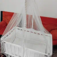گهواره چوبی کنار تخت مادر
