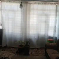 زیر پرده وچوب لباسی ایستاده