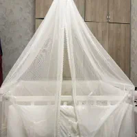 گهواره چوبی و تخت کنار مادر