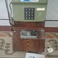 تلفن سکه ای دیواری با متحلقاتش
