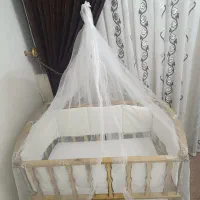 تخت خواب گهوارهای نوزاد کنار مادر