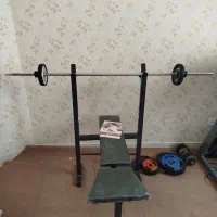 میز پرس سینه و میله هالتر و وزنه ۴۵ کیلو و دنبل