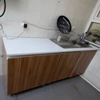 کابینت آشپزخانه همراه با شیرالات و سینک.