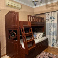 تخت دوطبقه طرح چوب و صندلی راک و پرده