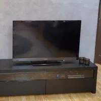 میز تلویزیون مدرن رنگ تیره براق و طراحی مینیمال