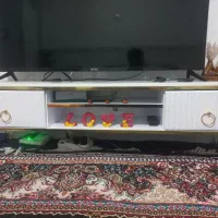 میزتلویزیون و پشتی وساعت ایستاده