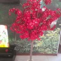 درختچه مصنوعی وتعدادی شاخه گل قرمز