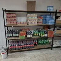 تعدادی قفسه آهنی و چوبی و میزکار استیل