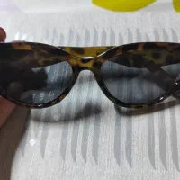 عینک قهوه‌ای ای در حد نو